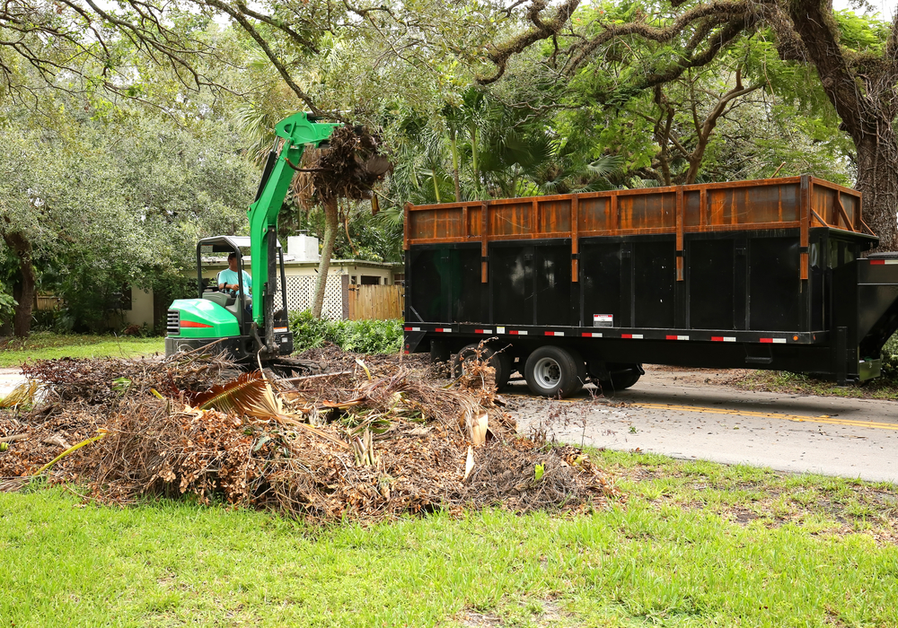 Equipment removing yard waste into waste truck